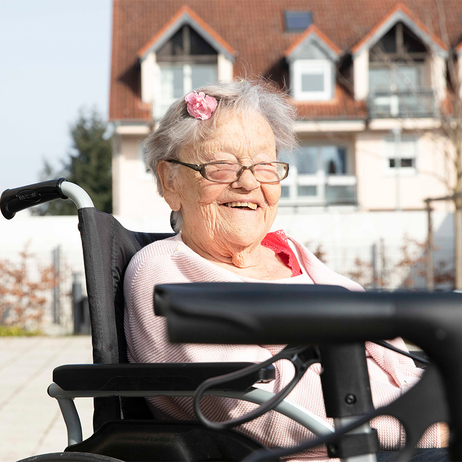 lächelnde ältere Frau im Rollstuhl