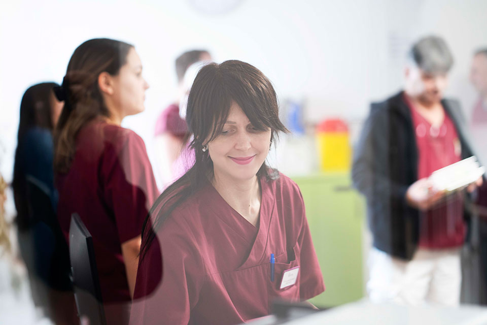 Pflegekräfte hinter einer Glasscheibe