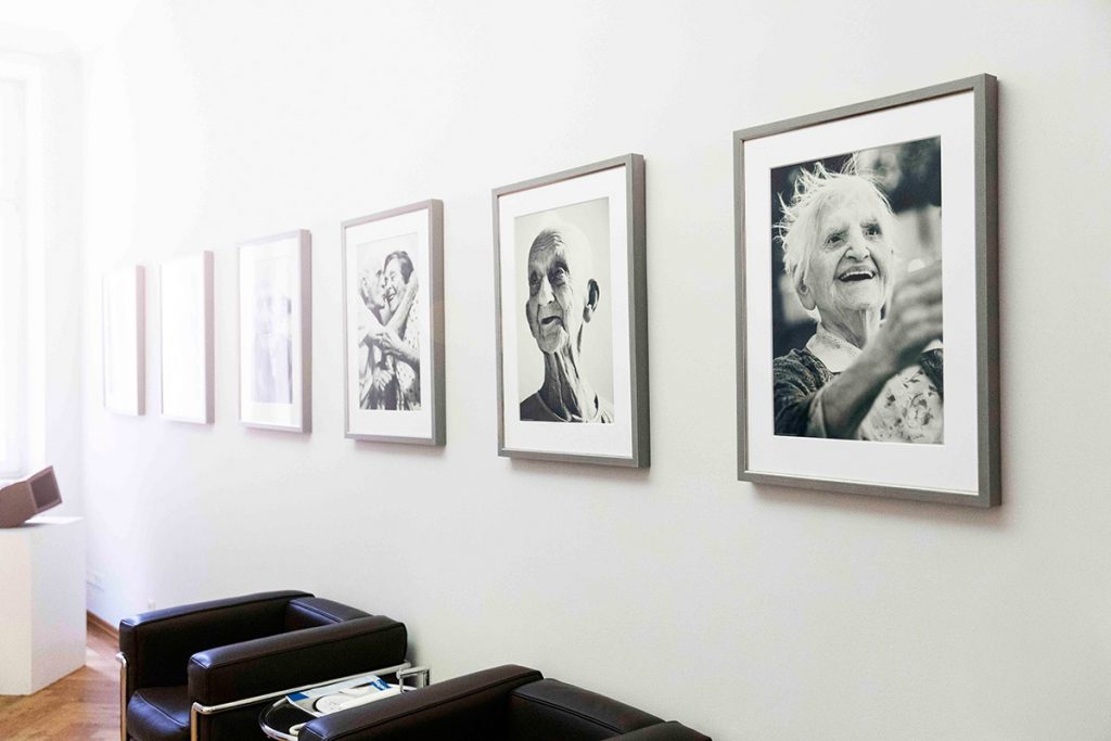 Porträtaufnahmen älterer Menschen an der Wand